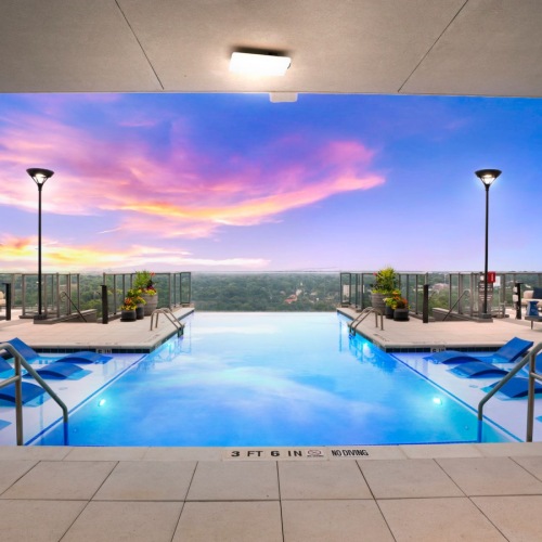 Rooftop Infinity Pool with Lounge Seating at Sunset Rooftop Infinity Pool with Lounge Seating at Sunset