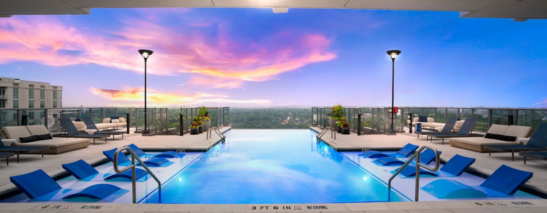 Rooftop Infinity Pool with Lounge Seating at Sunset
