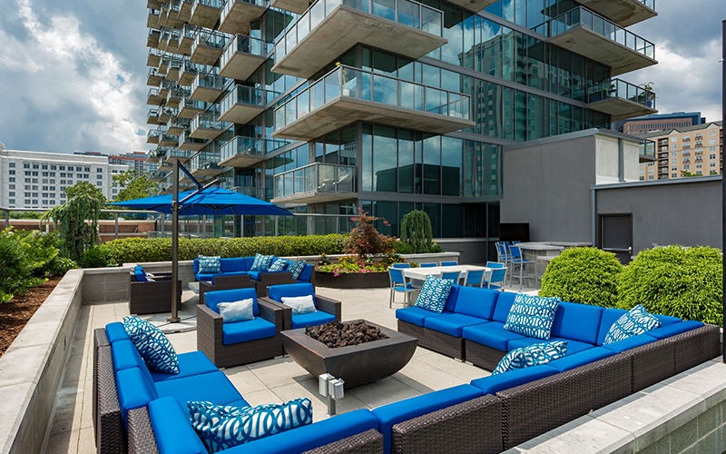 Large rooftop patio with seating and views of the city