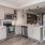 Spacious and well lit kitchen with wood floors and stainless steel appliances. 