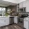 Spacious and well lit kitchen with wood floors and stainless steel appliances. 