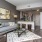 Spacious and well lit living room with wood floors and an open floor plan with access to the kitchen.