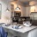 Spacious and well lit kitchen with wood floors and stainless steel appliances. 